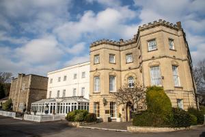 a large brick building in front of a building at Arnos Manor Hotel in Bristol