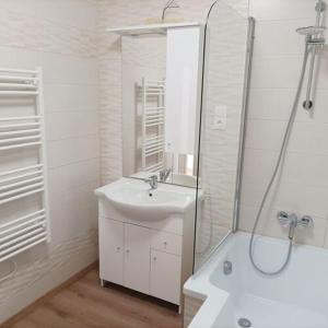 a white bathroom with a sink and a shower at Búzavirág házikó in Cserszegtomaj