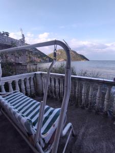 a chair sitting on a balcony overlooking the ocean at Apartman Nikola 