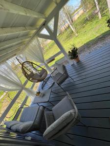 - une terrasse couverte avec 2 chaises et une balançoire dans l'établissement Domek nad jeziorem, à Myślibórz