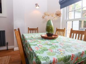 une table avec un tissu de table et un vase sur lui dans l'établissement Carpenters, à Sandwich
