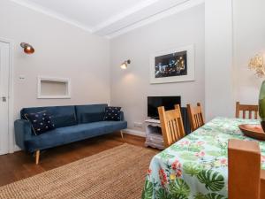 un salon avec un canapé bleu et une télévision dans l'établissement Carpenters, à Sandwich