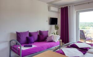 a purple couch in a living room with a window at Apartman Studio in Pula