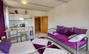 a living room with a purple couch and a kitchen at Apartman Studio in Pula
