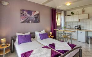 two beds in a small room with a kitchen at Apartman Studio in Pula