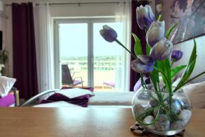 a vase filled with purple tulips sitting on a table at Apartman Studio in Pula