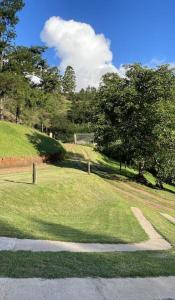 a grassy hill with trees and a road at Hoopoe Cottage in Drummond
