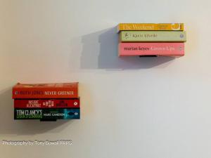 vier boeken bovenop elkaar op een muur bij Charming apartment next to Brighton Station in Brighton & Hove