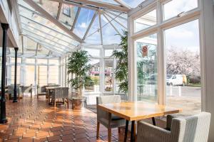 a conservatory with a table and chairs and windows at Arnos Manor Hotel in Bristol +45 photos