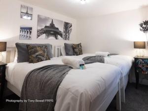 two beds in a room with white walls at Charming apartment next to Brighton Station in Brighton & Hove