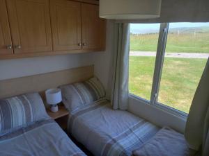 a bedroom with two beds and a window at Bay View - fantastic views of Whitsand Bay in Torpoint