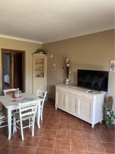un soggiorno con tavolo bianco e TV di CS Holiday a Castelnuovo Berardenga