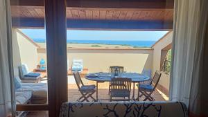 una mesa y sillas en un balcón con vistas al océano en Villetta Elisa Best Vacation Ever Sant'Elmo, en Costa Rei