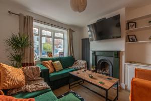 a living room with a green couch and a fireplace at Stylish Southampton City Centre House in Southampton