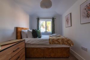 een slaapkamer met een bed, een dressoir en een raam bij Stylish Southampton City Centre House in Southampton