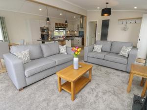 ein Wohnzimmer mit 2 Sofas und einem Tisch in der Unterkunft 48 Crosswinds in Bembridge