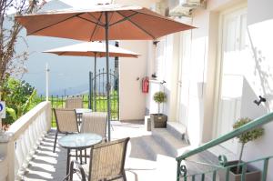 a patio with a table and chairs and an umbrella at Athina studios in Ipsos