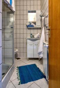 a bathroom with a sink and a blue rug on the floor at Apartman Studio in Pula