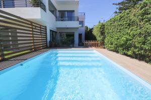 a swimming pool in front of a house at Cascais Getaway with a shared pool in Cascais