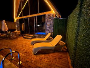 a pair of chairs sitting on a deck at night at ROSE SAPANCA STONE HOUSE in Sakarya