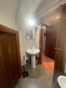 bagno con lavandino bianco e specchio di CS Holiday a Castelnuovo Berardenga
