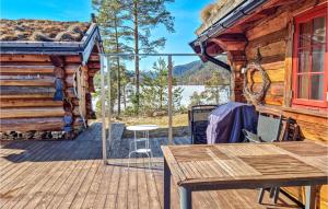 a cabin with a wooden deck with a table at Gorgeous Home In Dlemo With Wifi in Åmli