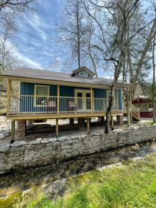 a home with a large porch and a house at All Seasons Treehouse Village in Eureka Springs