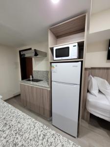 a kitchen with a white refrigerator and a microwave at Apartaestudio 21 Detrás del Hyper Jumbo con planta eléctrica in Maracay