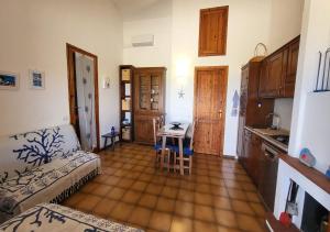 a kitchen with a couch and a table in a room at Villetta Elisa Best Vacation Ever Sant'Elmo in Costa Rei