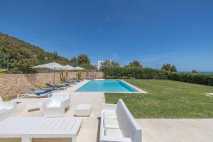 een villa met een zwembad en ligstoelen bij Villa con vistas al mar in Sant Jordi
