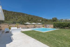 una piscina en un patio con tumbonas en Villa con vistas al mar en Sant Jordi