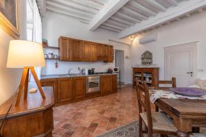 a kitchen with a wooden table and a dining room at Tina’s House in Cortona