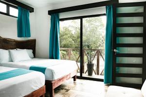 Hotel y Beach Club Casa Mia Xulha -Bacalar في Xul-Ha: غرفة نوم بسريرين ونافذة كبيرة