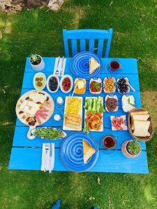 una mesa de picnic azul con un montón de comida. en Bonjourla Otel, en Urla