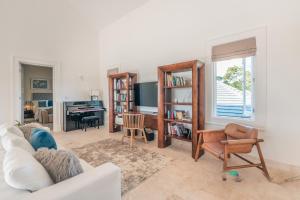 uma sala de estar com um sofá, uma cadeira e uma secretária em Majestic Golf View 4BR Villa at Punta Cana Resort em Punta Cana
