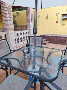 a table with two wine glasses and an umbrella at VILLA EL SALADO -ALQUILER RURAL ISABEL in Arriate