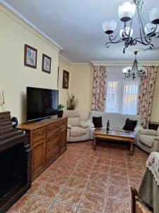 a living room with a flat screen tv and a couch at VILLA EL SALADO -ALQUILER RURAL ISABEL in Arriate