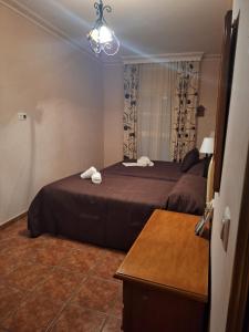 ein Hotelzimmer mit 2 Betten und einem Tisch in der Unterkunft VILLA EL SALADO -ALQUILER RURAL ISABEL in Arriate