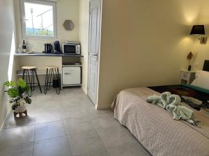 a small bedroom with a bed and a kitchen at Studio des Rêves de Giverny in Vernon