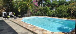 a swimming pool in a yard with aiki at bungalow tout confort avec piscine à 5 mn de la mer in Saint-François