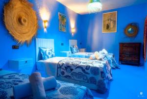 1 dormitorio azul con 2 camas y paredes azules en CASA TROUSSI, en Chefchaouen