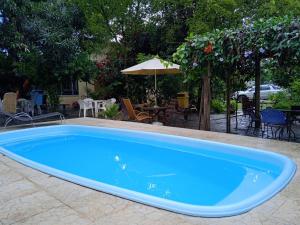 uma grande piscina azul num quintal em Pousada do Didi Chapada dos Guimaraes. em Chapada dos Guimarães