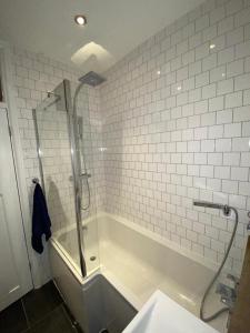 La salle de bains est pourvue d'une douche et d'une baignoire. dans l'établissement Three Bedroom Family home with garden in Walthamstow, à Londres