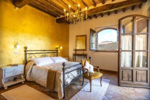 蒙塔尔奇诺Agriturismo Val di Tufo的一间卧室，里面有一张床、一把椅子和一扇窗户