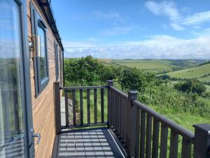 a balcony of a house with a view of the hills at Valley View - panoramic views of Rame in Torpoint