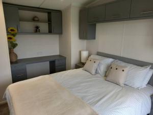 a bedroom with a bed with white sheets and pillows at Valley View - panoramic views of Rame in Torpoint