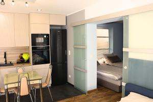 ein kleines Apartment mit einer kleinen Küche und einem Bett in der Unterkunft Apartament LIDER na wyłączność in Słupsk