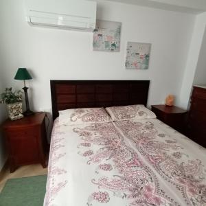 a bedroom with a bed with a pink and white comforter at La Cueva Beach in Altafulla