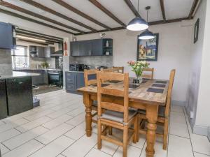 cocina y comedor con mesa de madera y sillas en Beach Cottage, en Rhyl