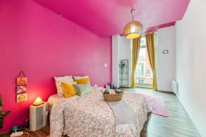 une chambre rose avec un lit et un mur rose dans l'établissement L'élégance- Centre Historique- Confort- Netflix- Marché Frais et Local, à Grenoble